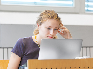 Eine Studentin schaut w?hrend einer Vorlesung auf ihren Laptop